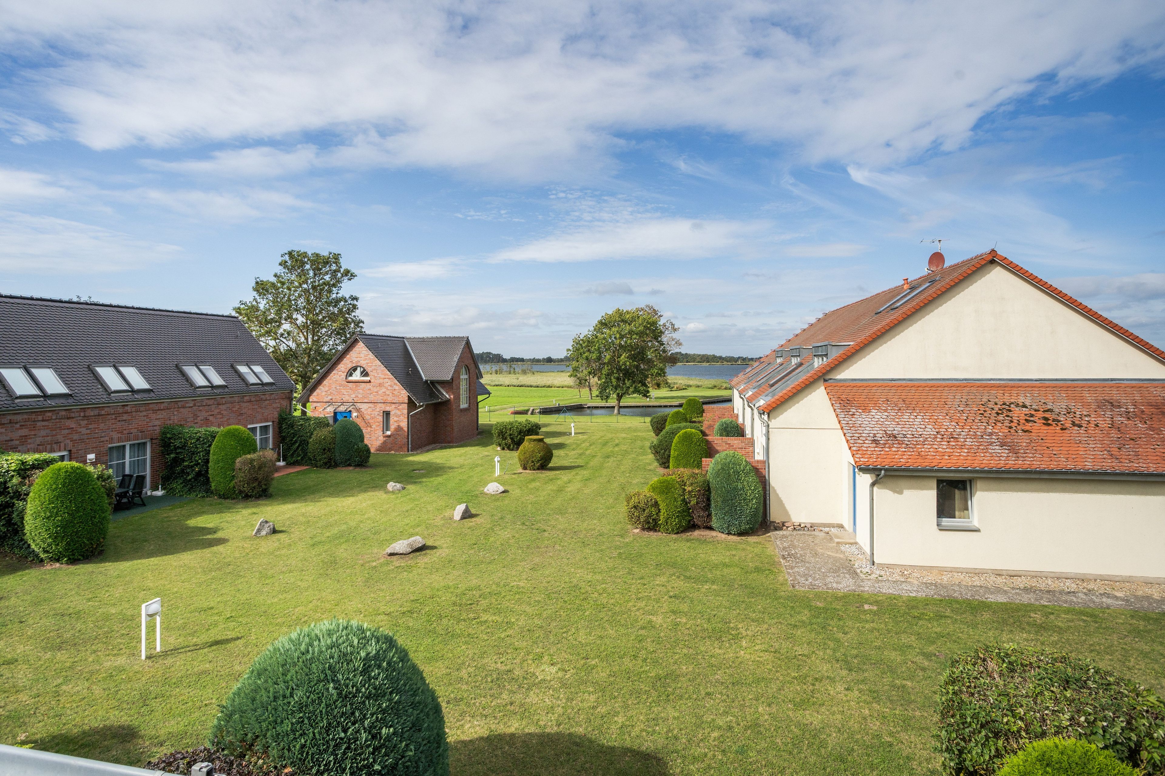 Un quartier résidentiel avec des maisons, une pelouse bien entretenue et un ciel dégagé.