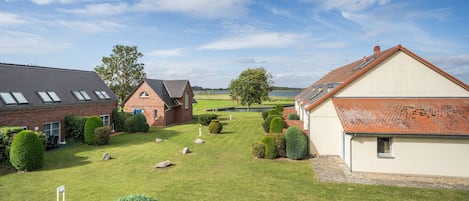 A residential area with houses, a well-maintained lawn, and a clear sky.