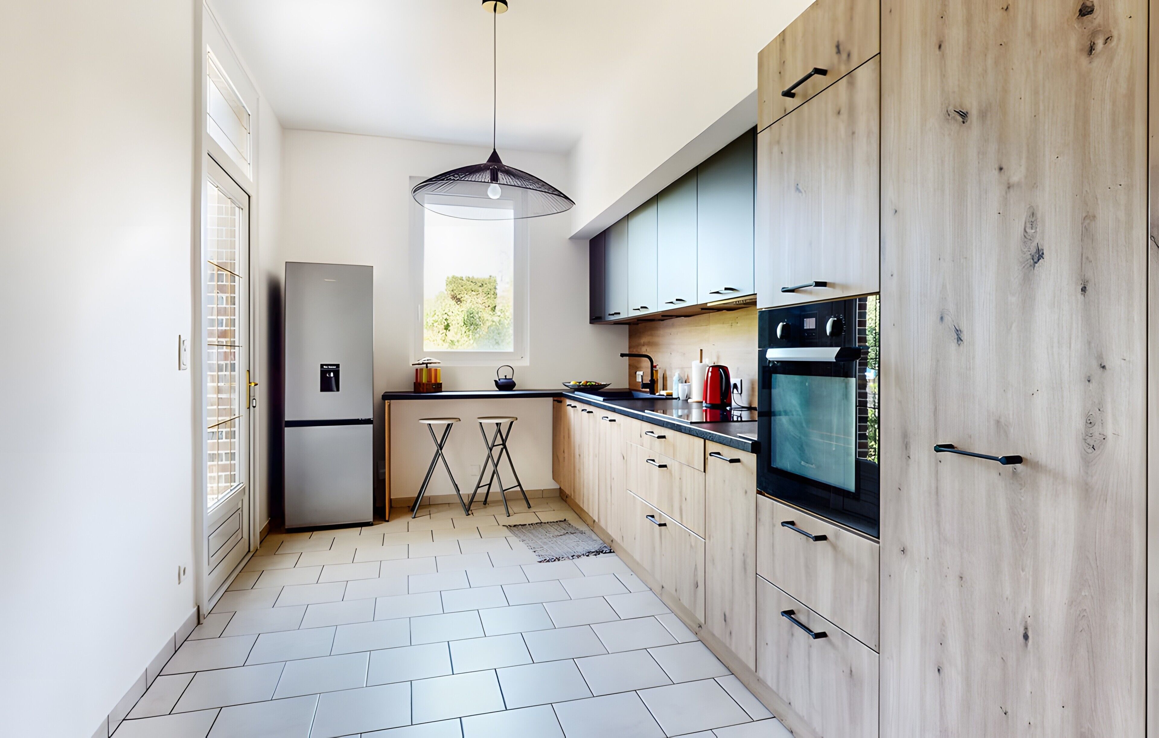 Une cuisine moderne équipée d’un réfrigérateur, d’une cuisinière et de meubles de rangement en bois.