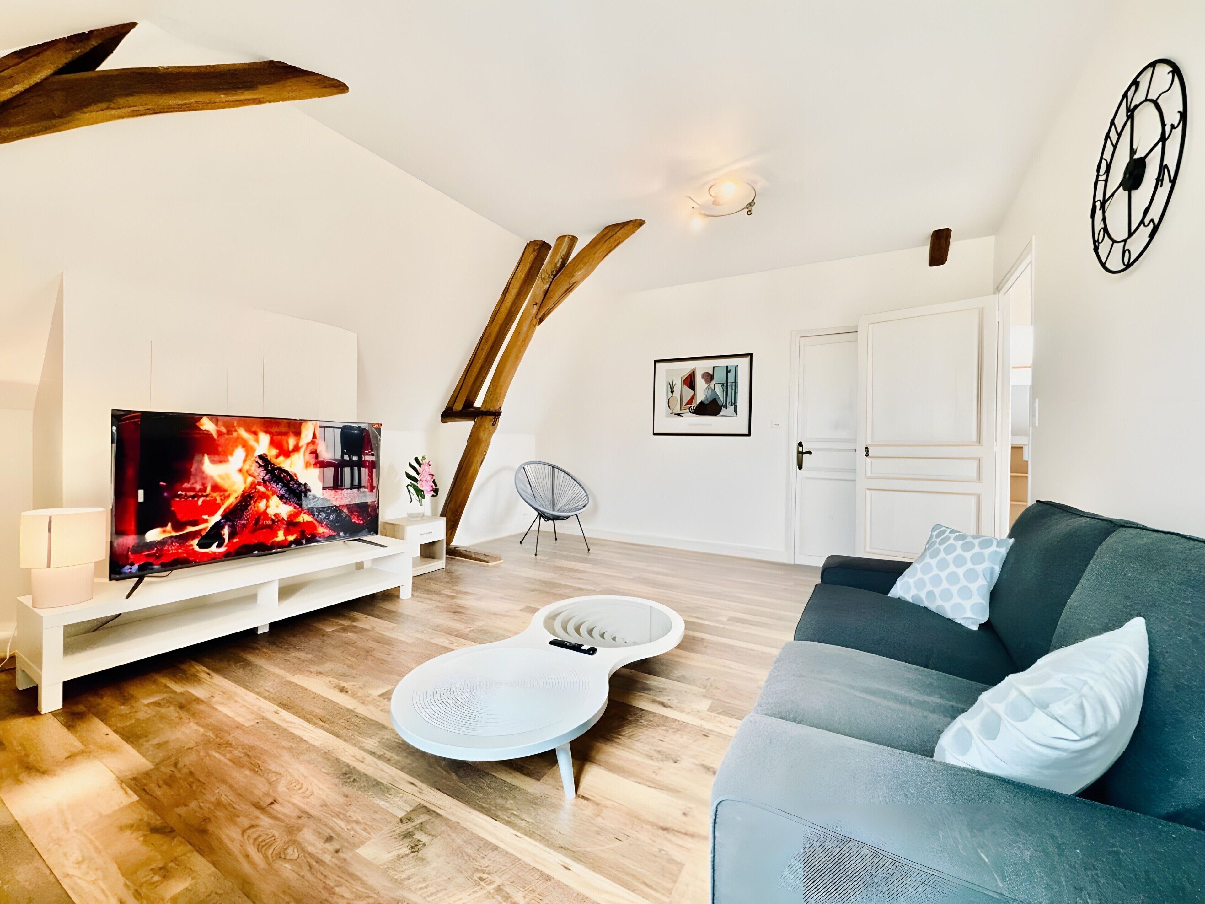 Un salon moderne doté d’un téléviseur à écran plat, de parquet, d’un canapé blanc et d’un design de plafond original.