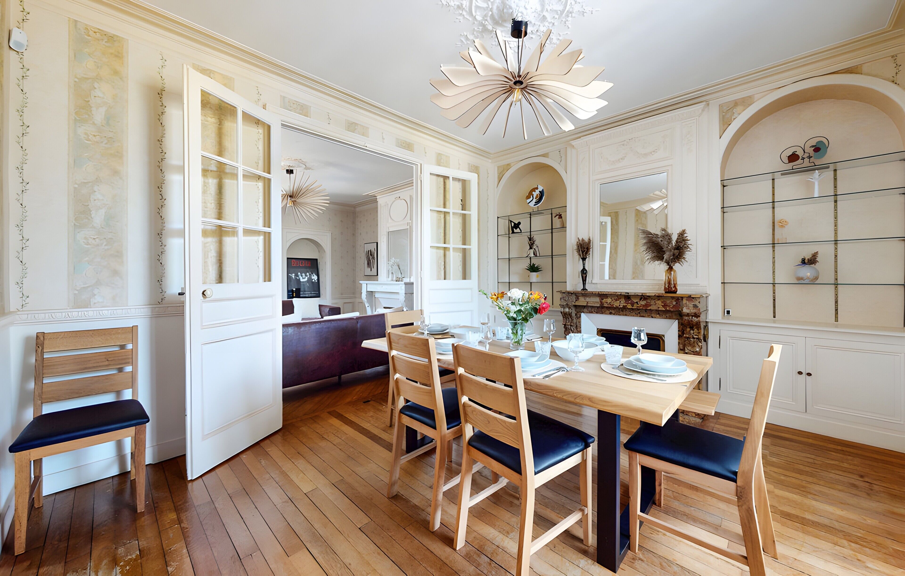 A dining area with a wooden table, chairs, and a chandelier.