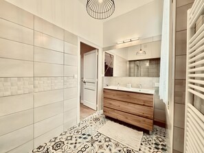 A modern bathroom with a wooden vanity, a shower, and a patterned floor. - Villa Sénone – Group Getaway in the Heart of Sens (Sens)