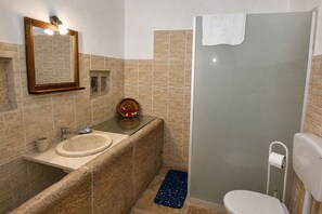 Un bagno con lavandino, specchio e doccia.