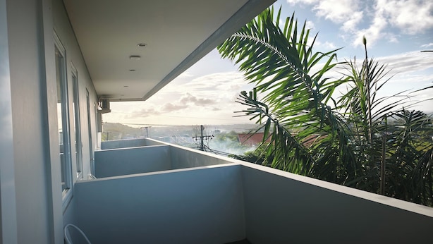 Un balcón con vistas a un puente y follaje.