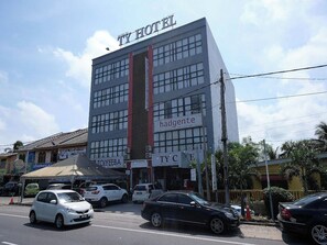 Un hotel de varios pisos con un letrero llamativo que dice 'TY HOTEL'.