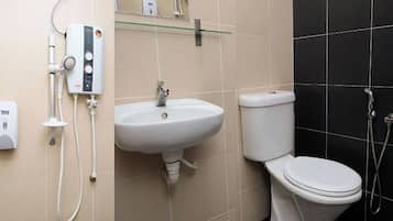 A bathroom with a toilet, sink, and shower.