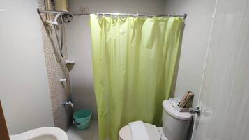 Un baño pequeño con inodoro, bidé y cortina de ducha.