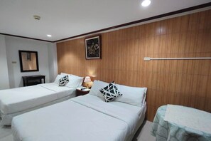 A hotel room with two single beds, a bedside table with a lamp, a wooden panel wall, and a framed picture. - Shenna's Beach Resort Boracay (Boracay Island)