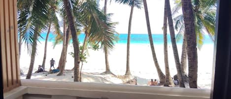 A view of a beach with palm trees and people.
