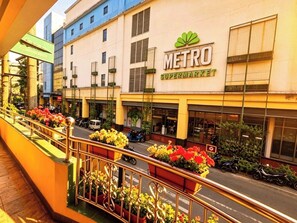 A Metro supermarket with a balcony railing and flower planters.