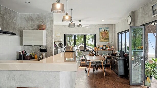 A modern kitchen with a central island, pendant lighting, and a view of the outdoors. - Para Hill Homestay (Pa Klok)