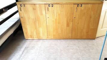 Ein Holzkabinent mit drei Abteilungen, beschriftet mit E-1, E-2 und E-3.