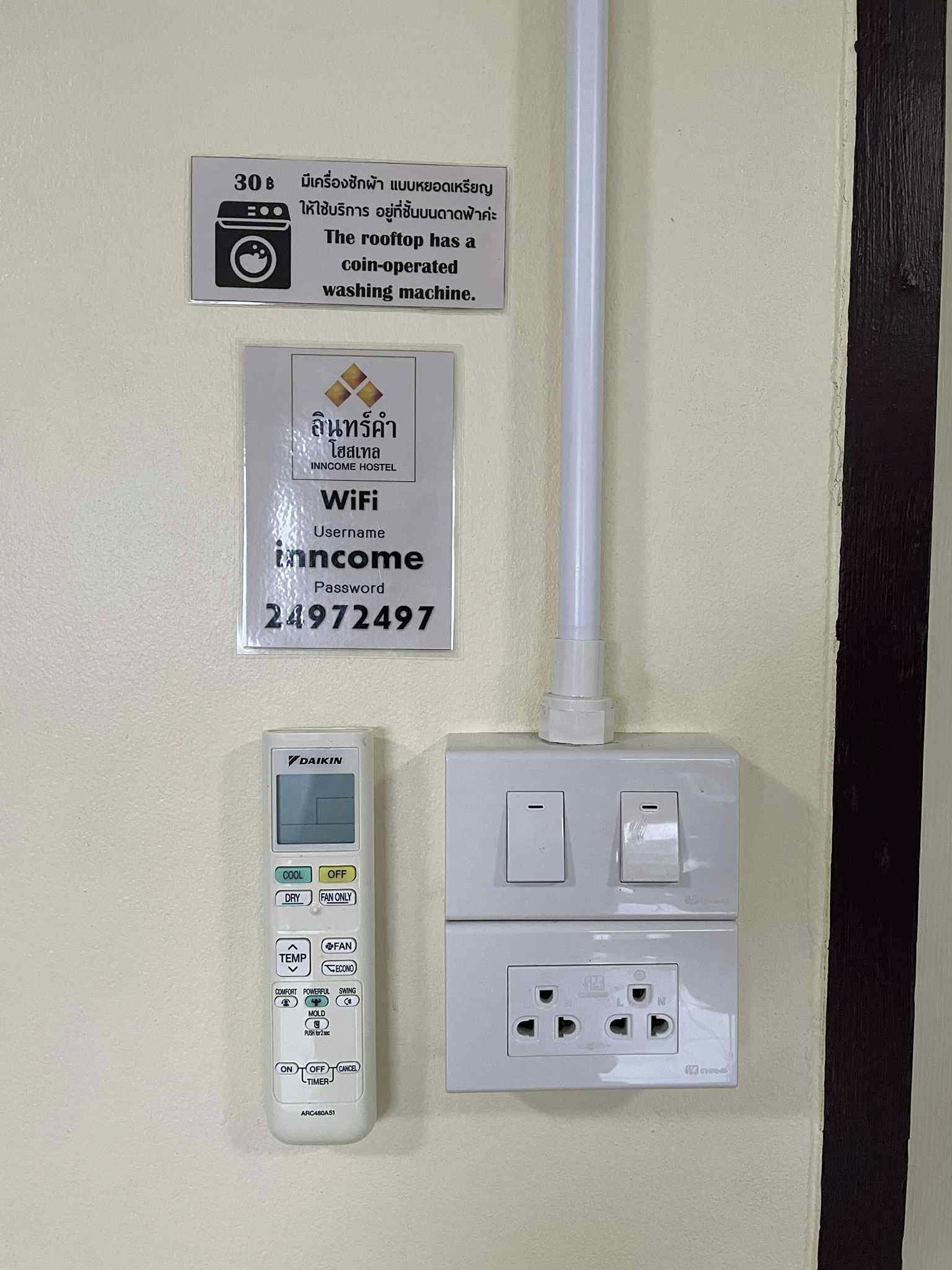 A wall-mounted washing machine, a WiFi sign, and a power outlet with a switch.