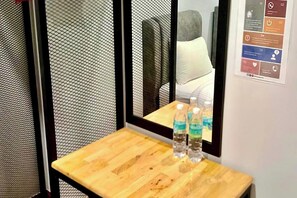 A hotel room with a wooden table, a mirror, and a wall-mounted information panel. - Km Barakah Suite Kuala Terengganu (Kuala Terengganu)