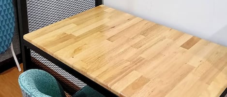 Una mesa de madera con una silla de mimbre.