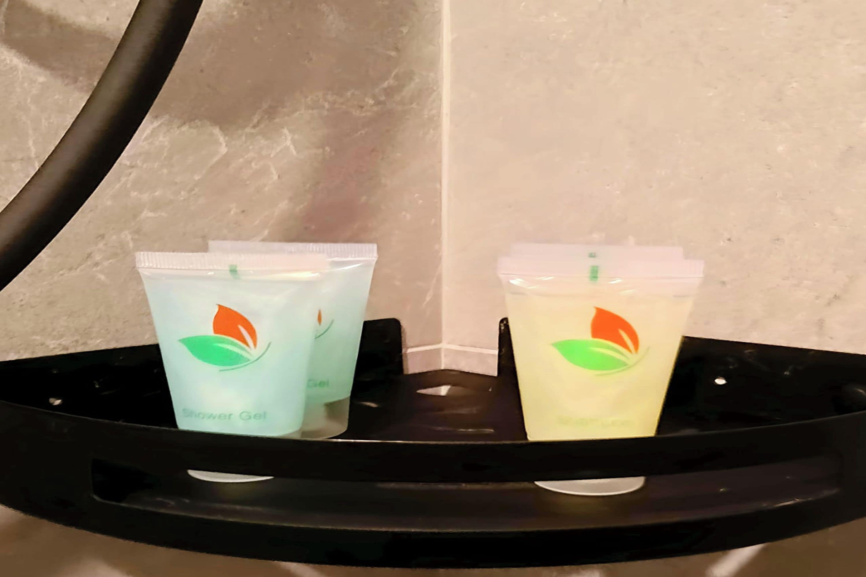 Dos envases de gel de ducha sobre una bandeja negra.