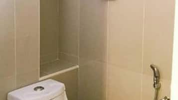 A bathroom with a toilet, a towel rack, and a shower.
