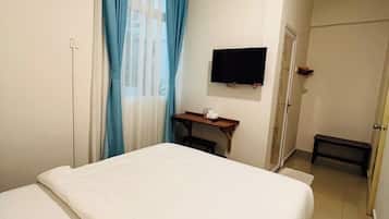 Habitació d'hotel amb un llit, una televisió penjada a la paret i un aparell d'aire condicionat.