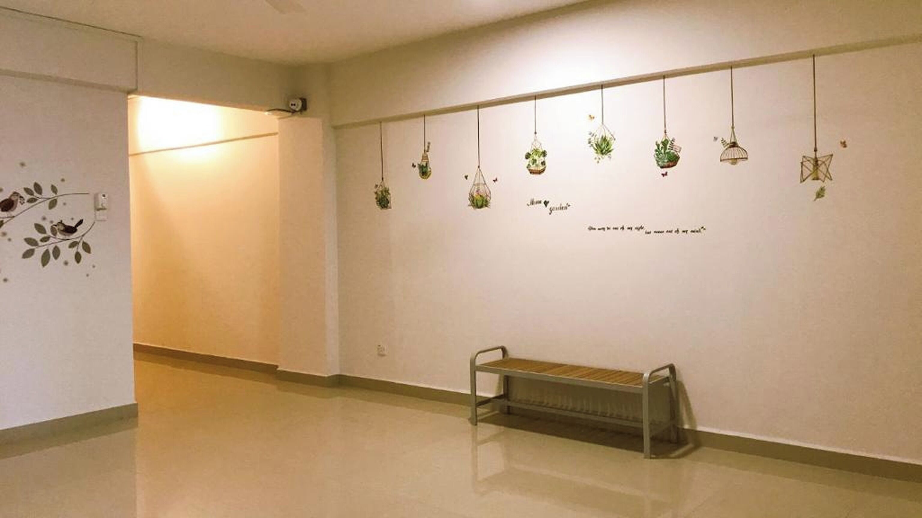 A hallway with a bench, a radiator, and hanging planters on the wall.