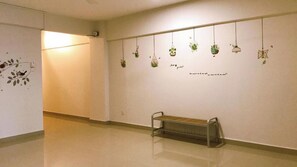 A hallway with a bench, a radiator, and hanging planters on the wall. - Alexis Kt Roomstay (Kuala Terengganu)