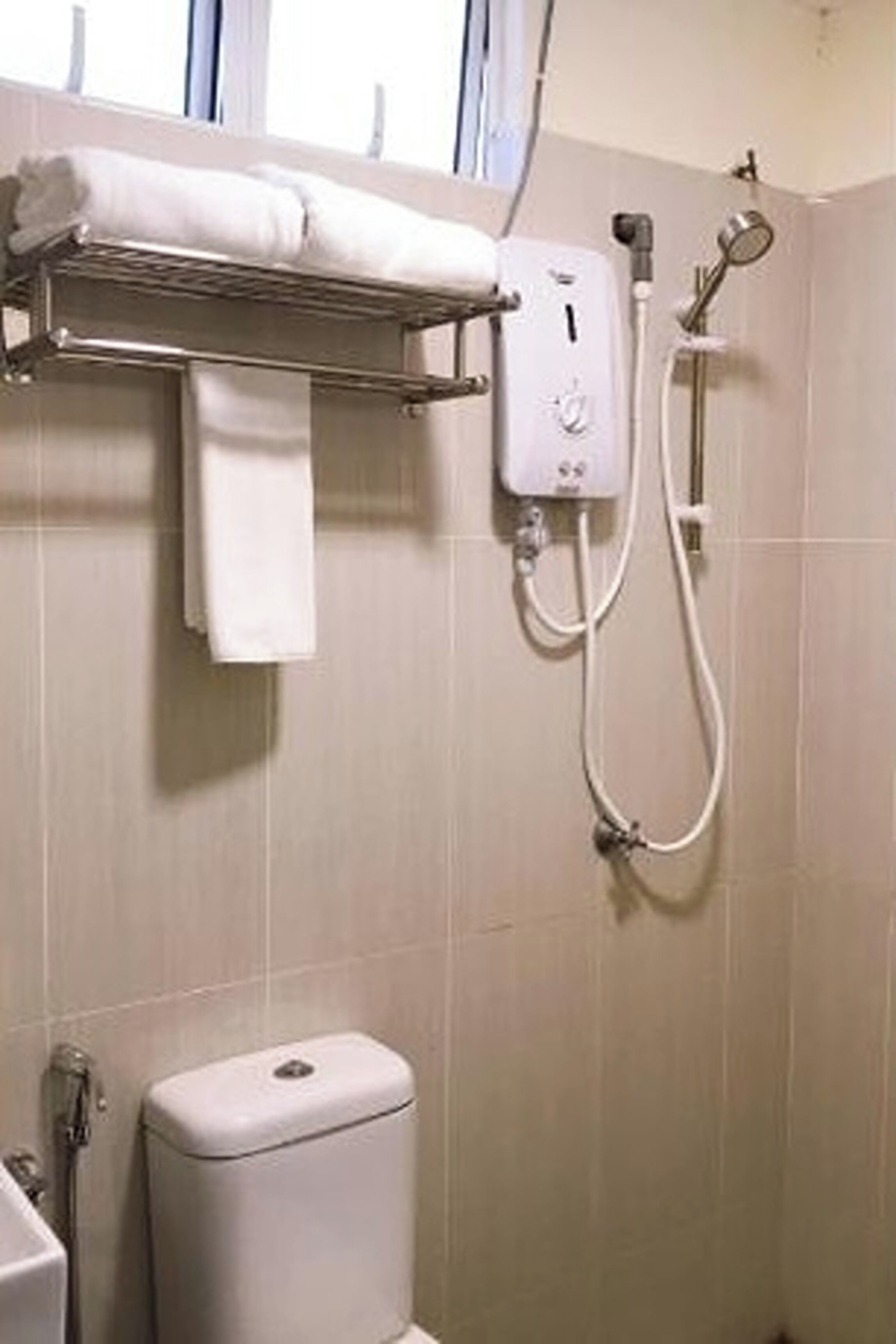 Ein Badezimmer mit Toilette, Handtuchhalter und Duschkabine.