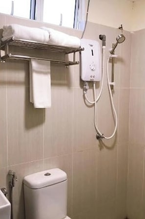 A bathroom with a toilet, a towel rack, and a shower unit.