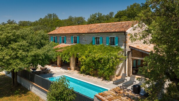 A stone villa with a swimming pool, surrounded by trees and greenery. - Old House Grota by Villas Guide (Umag)