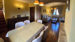 A dining area with a table and chairs, a sofa, a staircase, and a living area with a couch and a lamp. - Detached 4 Bedroom Villa With Pool (Valencia de Alcantara)
