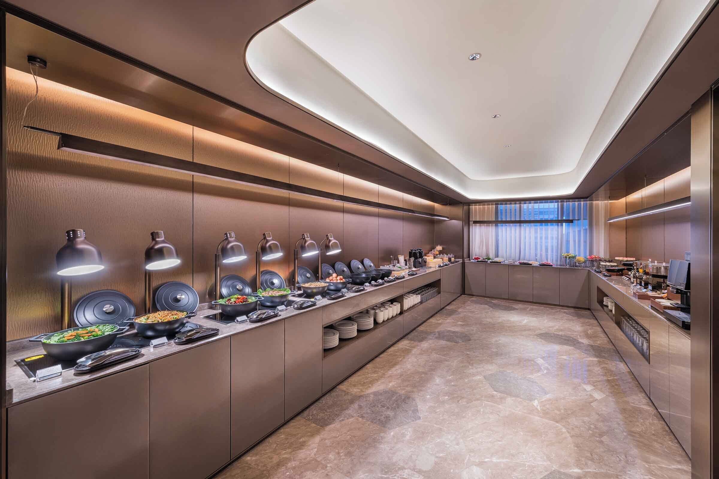 Un espace buffet moderne et bien éclairé, offrant une grande variété de plats et arborant un design élégant et contemporain.