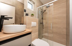 A modern bathroom with a round sink, a glass shower enclosure, and a wooden vanity. - Luxurious home in Biograd (Biograd)