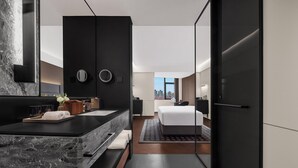 A modern hotel room with a marble sink, a bed, a large mirror, and a city view. - IntercityHotel Shanghai World Expo Hotel (Shanghai)