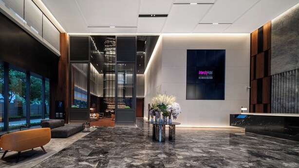 A modern hotel lobby with a reception desk, seating area, and large windows offering views of the outdoors. - IntercityHotel Shanghai World Expo Hotel (Shanghai)