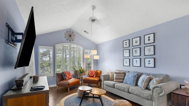 A living room with a sofa, armchairs, a coffee table, a TV, and artwork on the wall. - True Blue Golf & Beach Getaway (Pawleys Island)
