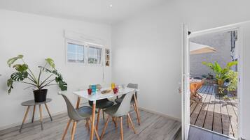 A dining area with a table, chairs, and potted plants.