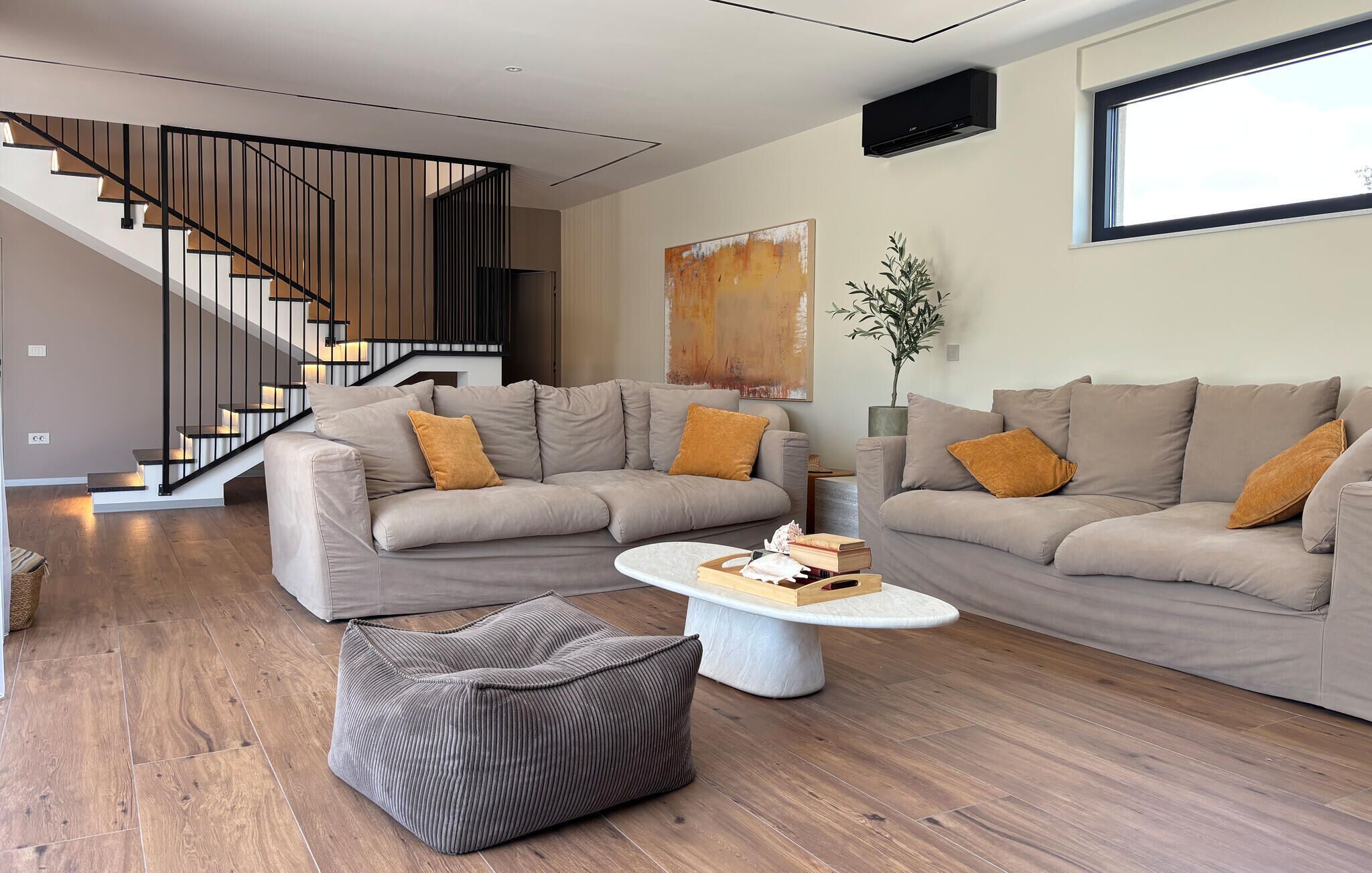 Un salon moderne avec deux canapés, une table basse et un escalier.