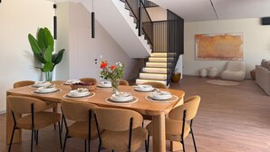 A dining area with a wooden table set for six, surrounded by six chairs. A staircase with a black railing leads to an upper level. - Awesome home in Kringa (Kringa)