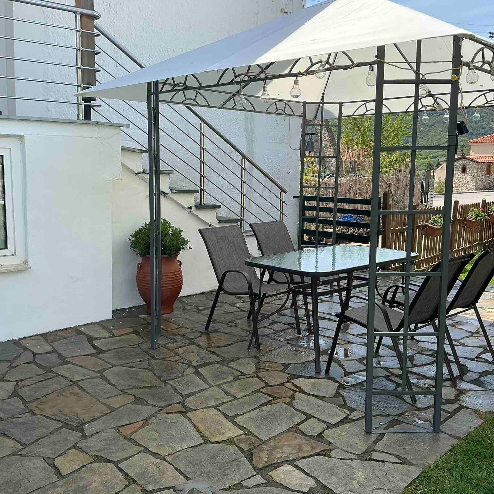 Un patio con una mesa y sillas, una planta en maceta y una escalera.