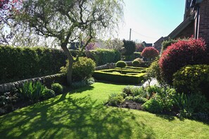 Un jardín bien cuidado con una variedad de plantas y un seto ordenado.