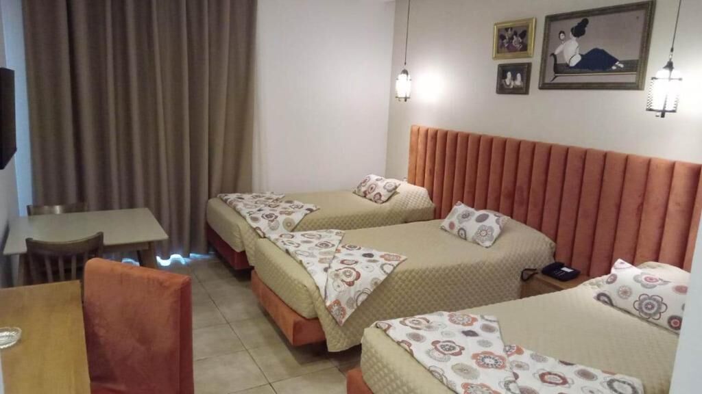 Una habitación de hotel con dos camas, una mesa y sillas.