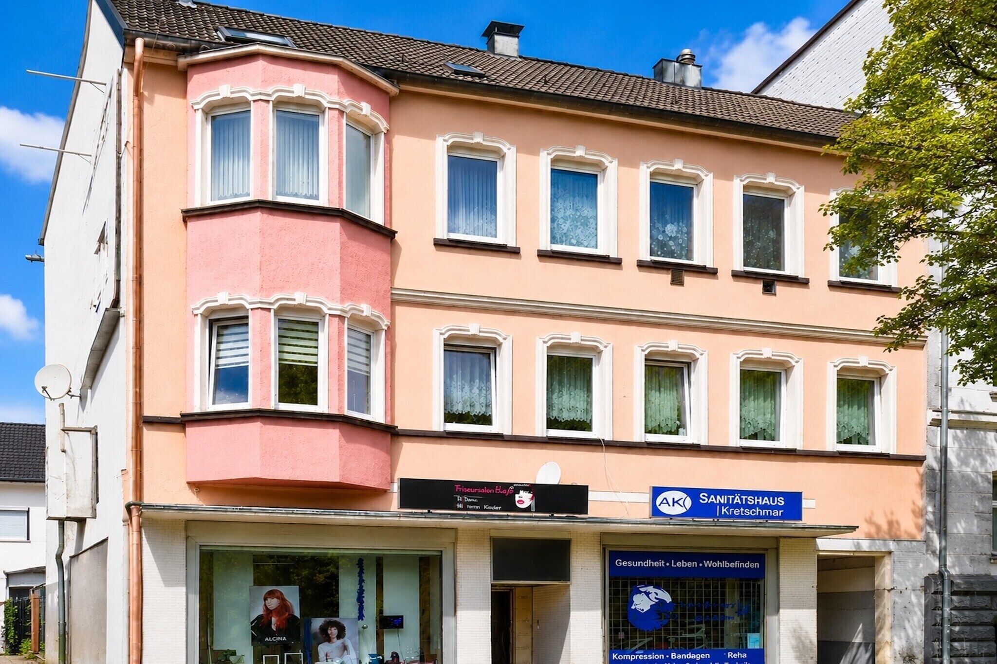 Un bâtiment à la façade rose, doté de nombreuses fenêtres et d’une enseigne indiquant qu’il s’agit d’un sanatorium.