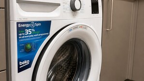 Un lave-linge à chargement frontal doté d’un panneau de commande, d’une porte à chargement frontal et d’une étiquette indiquant son niveau d’efficacité énergétique.