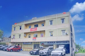 A multi-story building with a sign 'OYO' and a 'RAKA MOTOR' shop.