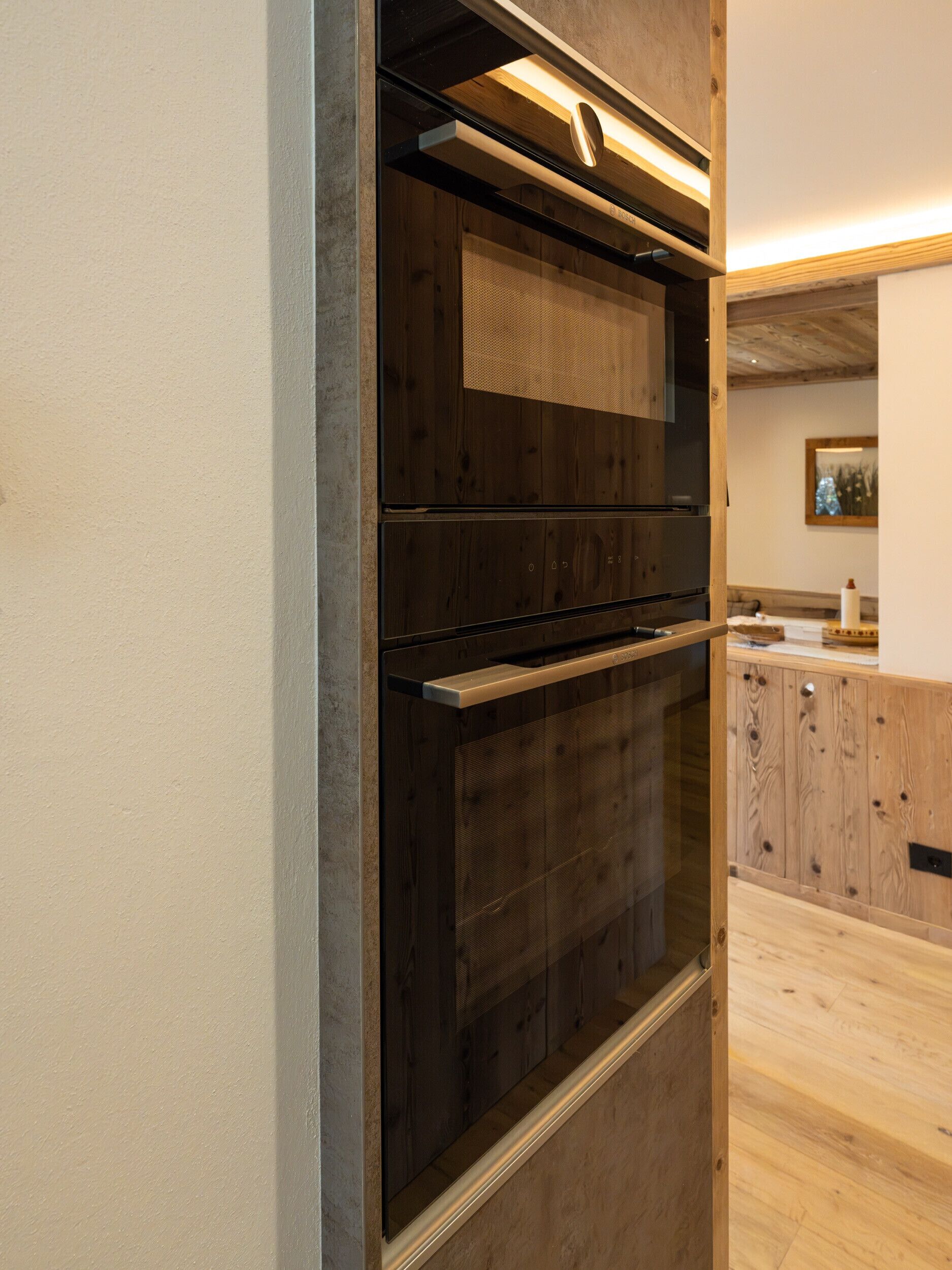 Una cocina moderna con electrodomésticos integrados, armarios de madera y encimera.