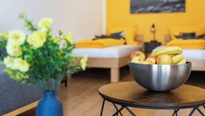 A room with a bed, a bowl of fruit, and a vase of flowers. - CASATUA Sun Design - Quiet - Workspace - Balcony - Trade Show - WiFi (Wuppertal)