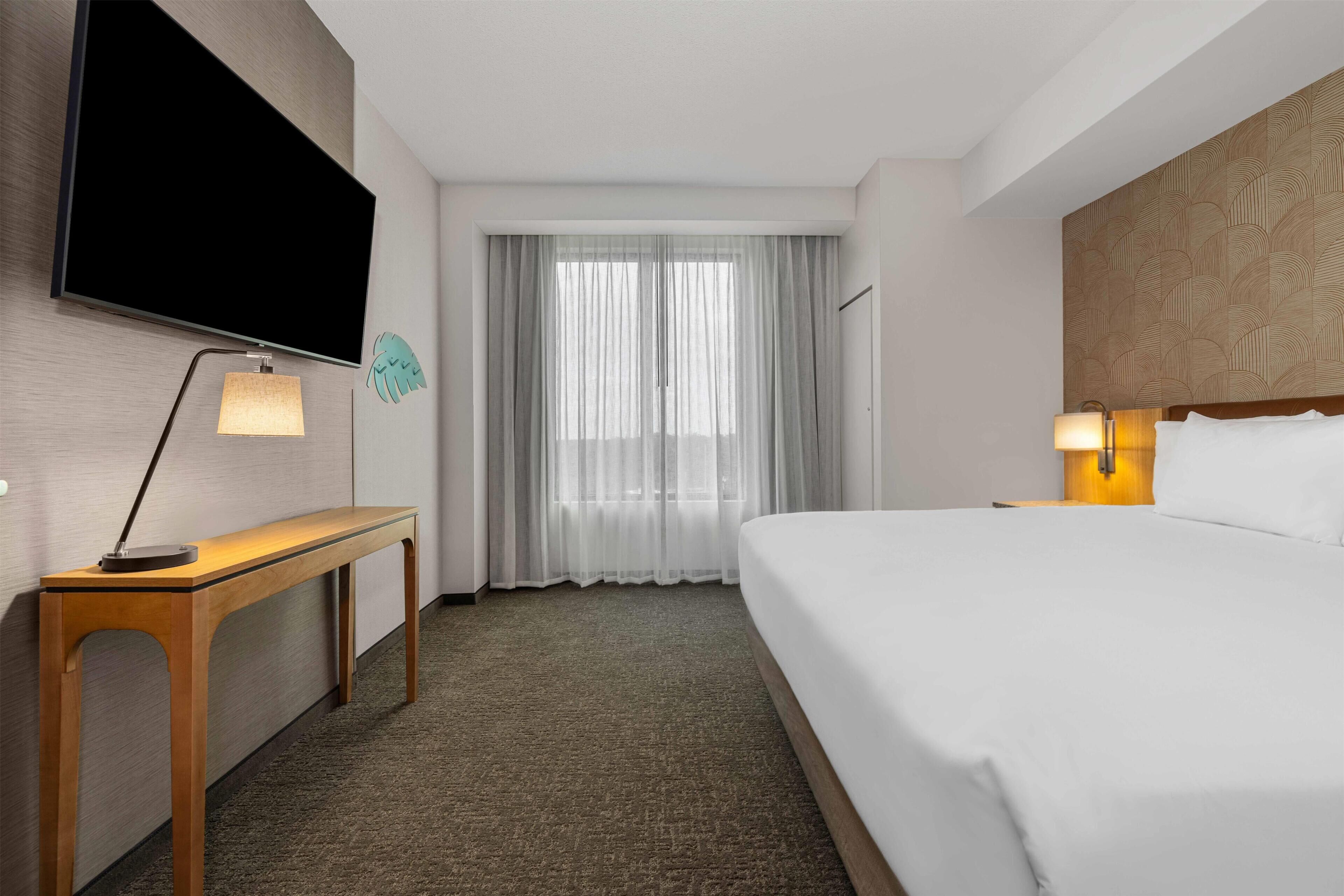 Premium bedding, desk, laptop workspace, blackout drapes