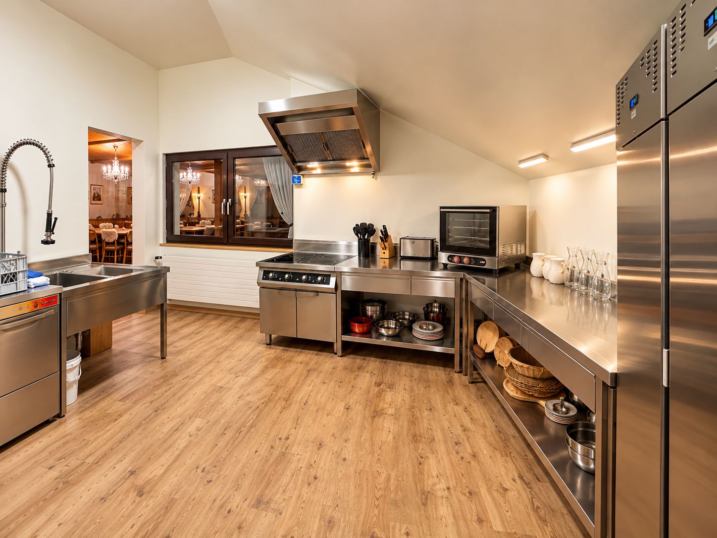 A modern kitchen with stainless steel appliances, a wood floor, and a view to a dining area.