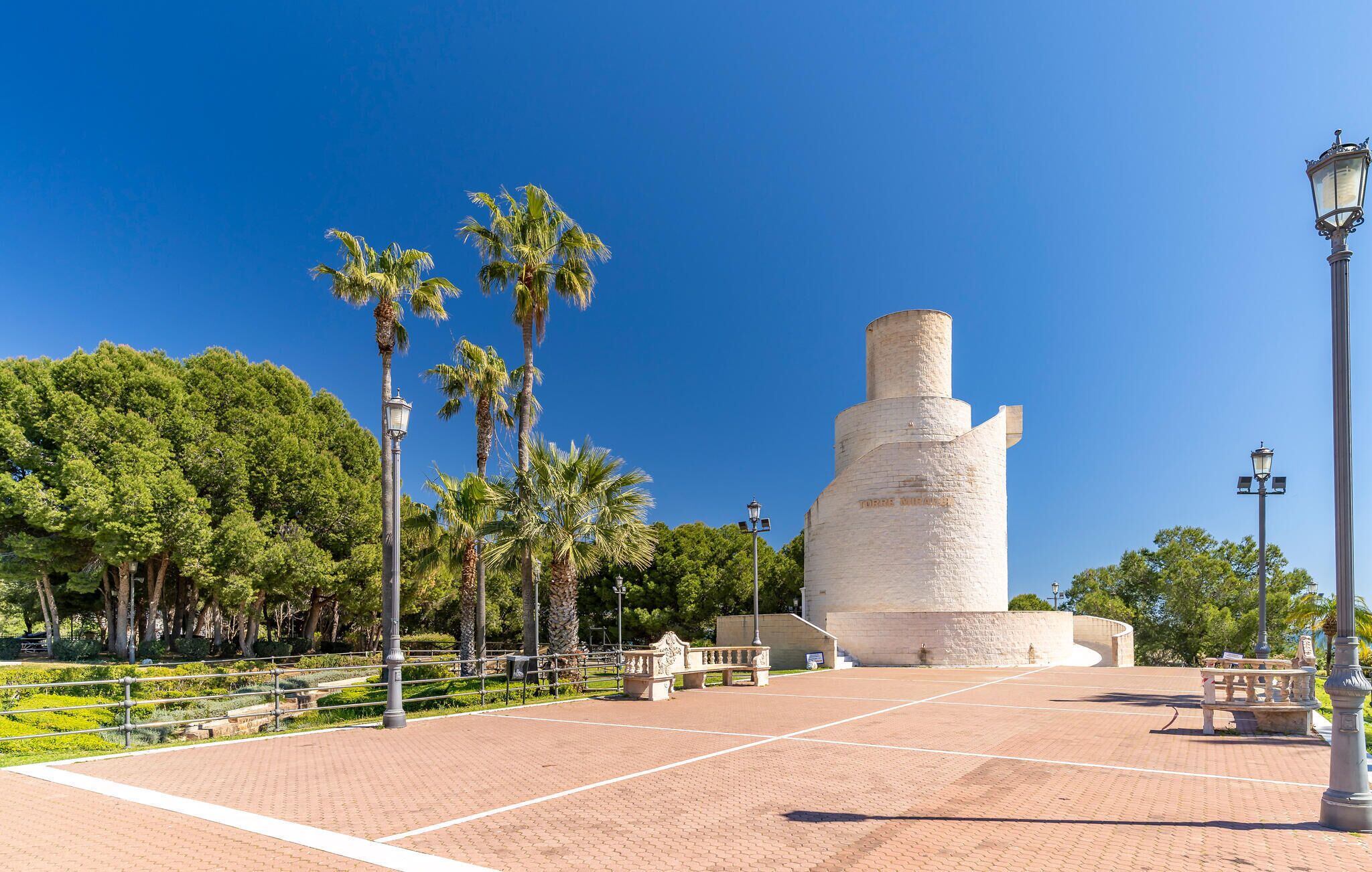 Un grand monument blanc dans un parc, sous un ciel dégagé.