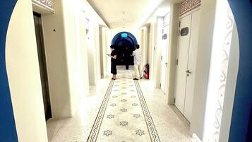 A hallway with a patterned carpet, white walls, and a blue archway.