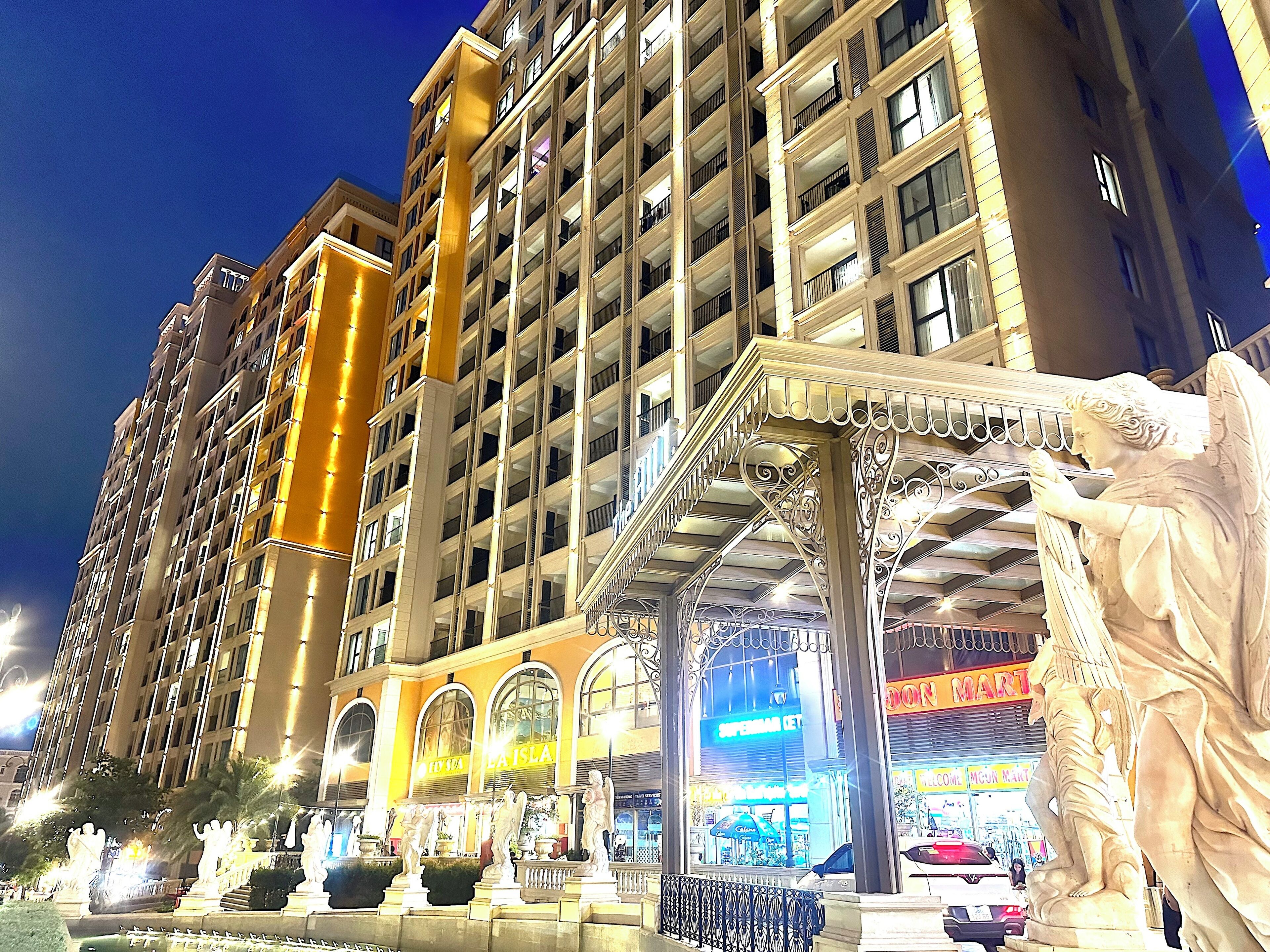 A multi-story hotel with balconies, a central atrium, and a statue.