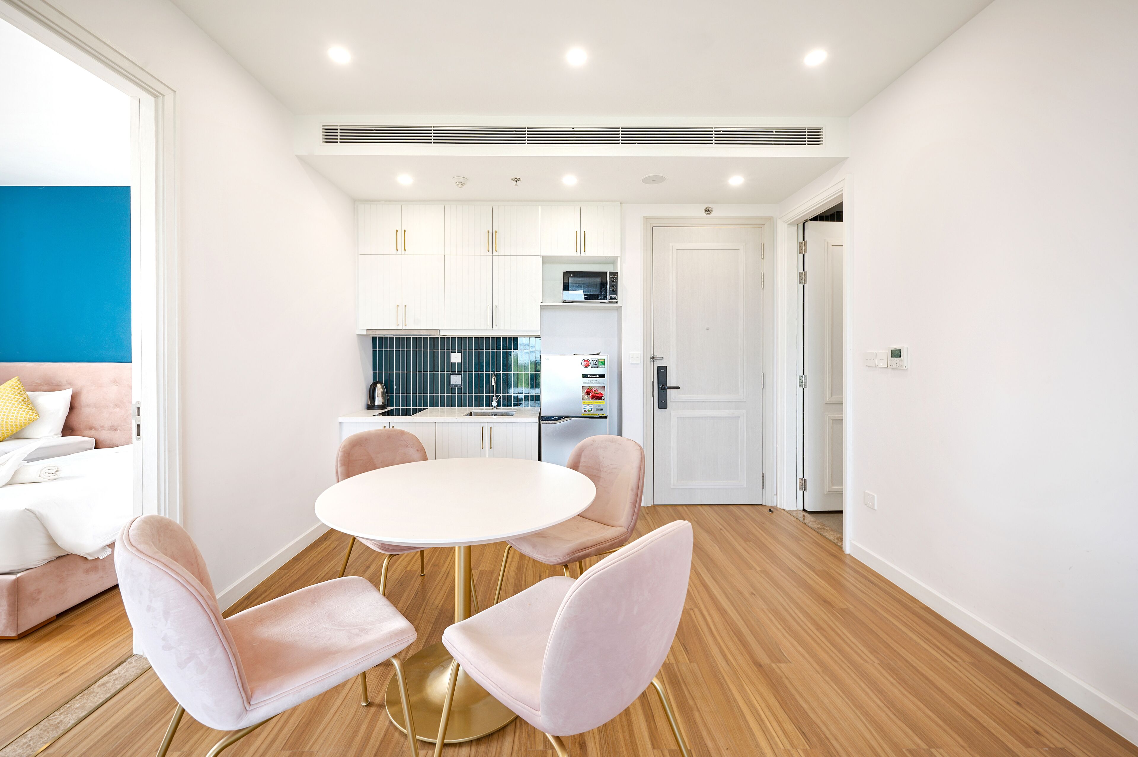 A modern kitchen with white cabinets, a microwave, and a refrigerator.
